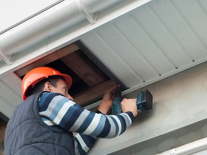 Worker installing new soffit